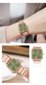 Detail of rose gold square watch with emerald green sunray dial and steel strap