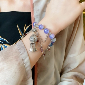 Detail of purple beaded flower wind chime bracelet with vintage silver lantern charms