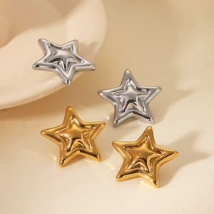Macro view of gold and silver layered star earrings with mirror polished finish