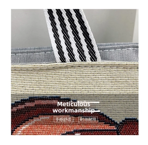 Detail of reinforced stitching on the woven tote bag with black and white striped handle