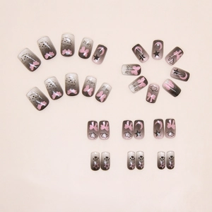 Detail of cat eye gradient press-on nails with pink bows and cute star moon charms