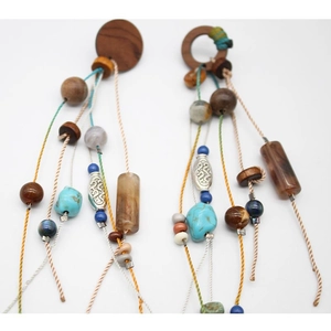 Detail of bohemian drop earrings featuring colorful wooden beads and woven cotton tassels