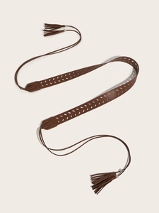 Detail of vintage PU leather belt featuring laser-cut leaf patterns and fringe tassels