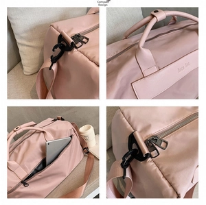 Close-up of pink fitness bag details with durable hooks and side tablet pocket