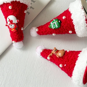 Detailed close-up of plush Christmas hat hair clips with pearls and 3D holiday charms