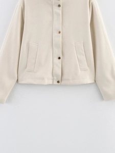 Detail of cream fleece jacket featuring metal snap buttons and side pockets on textured fabric