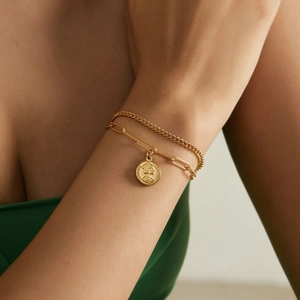 Ensemble de bracelets double couche en or avec croix et pendentif pièce sur un poignet