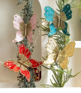 Detail of velvet butterfly ornaments with rhinestones and gold glitter on pine branches