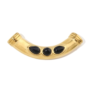 Detail of a vintage gold-plated bead pendant with three black inlaid stones for DIY jewelry
