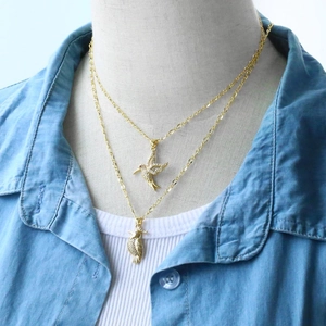 Close-up of golden hummingbird and parrot pendants with sparkling diamond accents