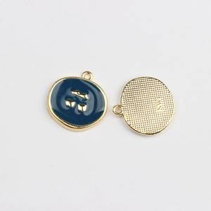 Detail of round star moon cherry enamel charms showing front blue finish and gold textured back