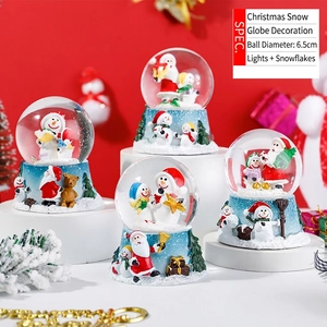 Detail of 6.5cm Christmas snow globes with resin bases showing Santa and LED lights