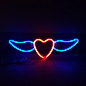 Détail de l'enseigne néon cœur avec ailes éclairée par des LED rouges et bleues