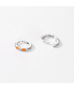Detailed macro shot of S925 silver huggie earrings with orange enamel and zircon inlay