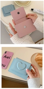 Detail view of macaron faux leather wallets with heart embossing in pink and blue colors