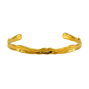Macro shot of 18K gold-plated irregular hammered texture and polished metal on the bangle