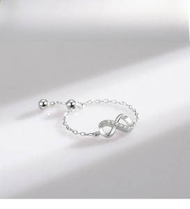 Detail of adjustable silver chain ring with crystal infinity symbol and ball sliders