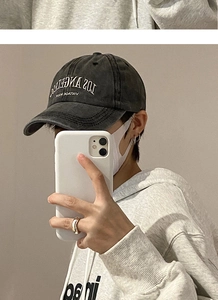 Detail of Los Angeles embroidery on vintage washed cotton baseball cap worn by model