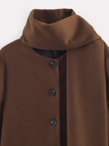 Detail of dark brown wool coat collar with black buttons and premium fabric texture