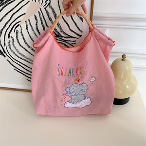 Detailed embroidery of a cute elephant on a pink nylon tote bag with rope handles