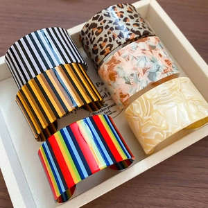 Close-up of colorful acrylic open bangles with vertical stripes and marble patterns