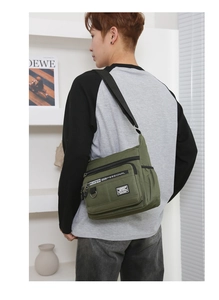 Model wearing army green multi-pocket crossbody bag with high capacity and waterproof canvas