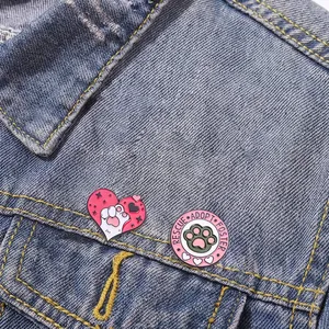 Halloween cat paw enamel pin set on denim jacket featuring rescue and adopt slogan design