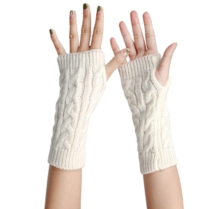 Detail of cable knit texture on cream white fingerless arm warmers for winter fashion