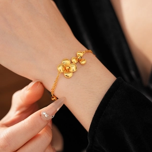 Detail view of gold flower bracelet with matte texture petals and adjustable chain