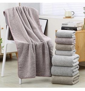 Close-up of thick charcoal fiber towels showing soft texture and reinforced edging