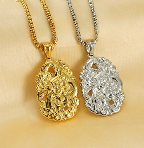 Macro detail of gold and silver stainless steel dragon relief pendants on silk
