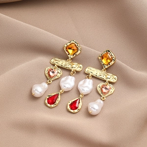 Detail of baroque pearl drop earring with mixed crystals and gold-tone finish