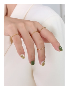 Minimalist gold band rings set on female hand showing elegant multi-stacking style