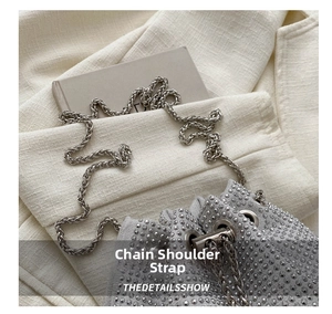 Detailed close-up of a silver rhinestone bucket bag with a metallic woven chain strap