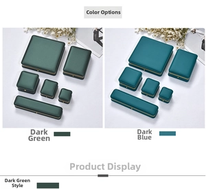 Close-up of luxury jewelry gift boxes with gold trim in dark green and navy blue finishes