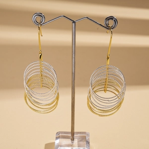 Detail of layered geometric hoop earrings with gold and silver metallic finish