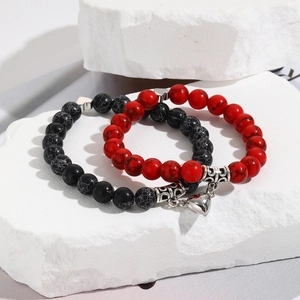 Close-up of heart magnetic charms on textured beaded bracelets for couples
