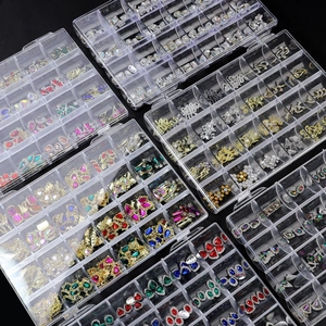 Detailansicht der 24-Gitter-Box mit bunten Nagelkunst-Anhängern und funkelnden Edelsteinen