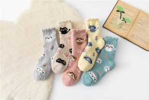 Detailed arrangement of five colorful coral fleece cat socks on a plush white background