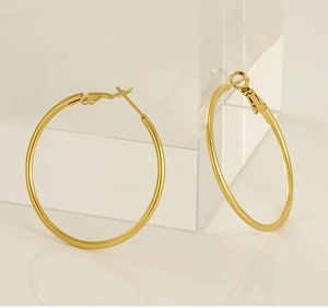 Detail of large 18K gold plated matte hoop earrings with a secure latch closure