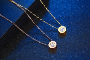 Macro view of gold and rose gold round necklaces with Roman numerals and cubic zirconia