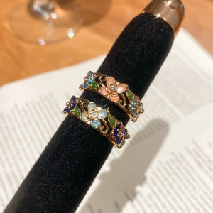 Close-up of gold-plated flower ring with colorful enamel petals and sparkling zircons