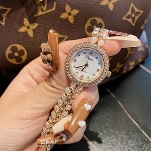 Elegant women's quartz watch with shell dial, rhinestone bezel, and pearl chain strap