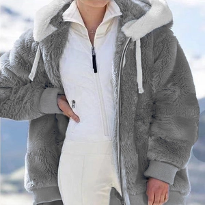 Detail of dark grey plush hooded jacket with white fur trim and quilted inner vest