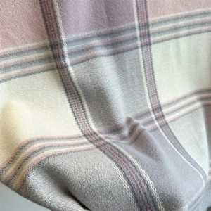 Detailed macro view of soft plaid fabric texture in pastel pink, purple and grey shades