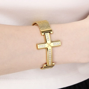 Detailed view of golden stainless steel mesh bracelet with sparkling cross and white zircons