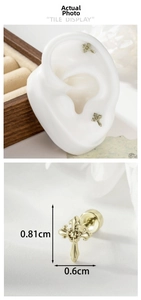 Macro view of gold cross stud earrings with lily floral textures and size dimensions