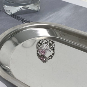 Macro shot of silver ring with pink heart stone and zircon pave on metal tray
