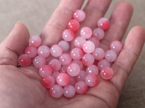Nahaufnahme von rosa-weißen Jadeperlen mit Farbverlauf für DIY-Schmuckherstellung
