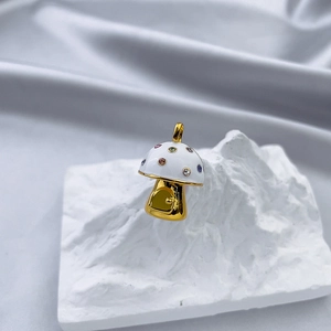 Detailed view of a gold mushroom house pendant with white enamel and colorful crystals